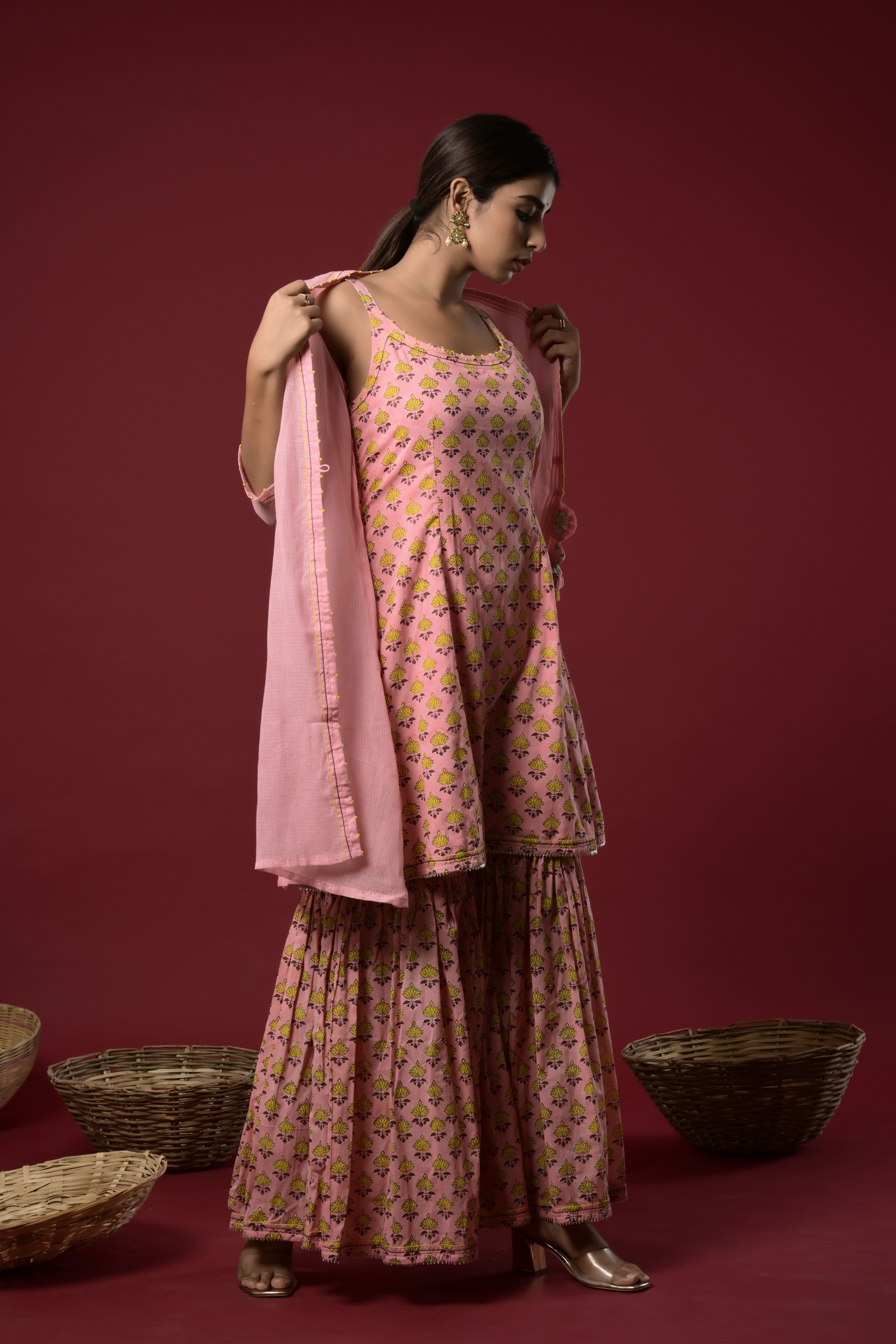 Block printed short kurta and sharara with embellishment on the neck and kota doriya jacket with tassel in the front.
